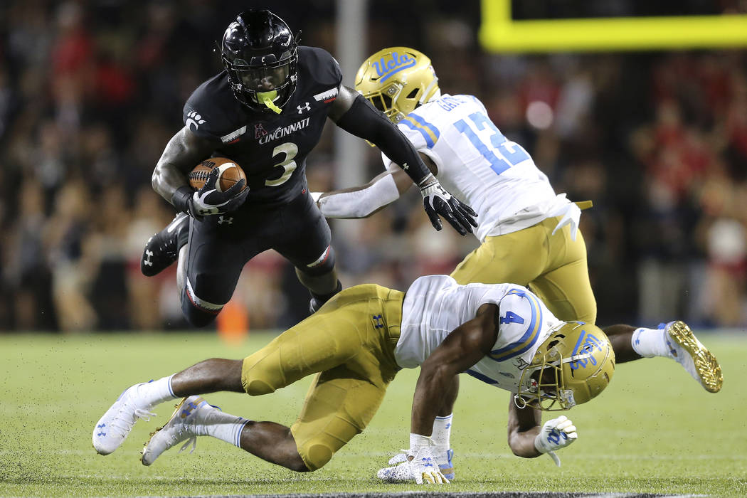 Cincinnati running back Michael Warren II (3) is upended by UCLA Bruins defensive back Stephan ...