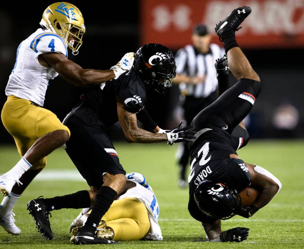 UCLA defensive back Elijah Gates (12) tackles Cincinnati running back Gerrid Doaks (23) during ...