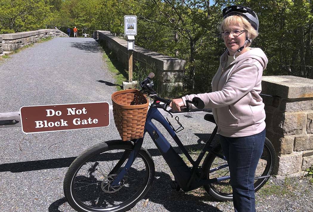 In a June 8, 2019, file photo, Janice Goodwin stands by her electric-assist bicycle at a gate n ...