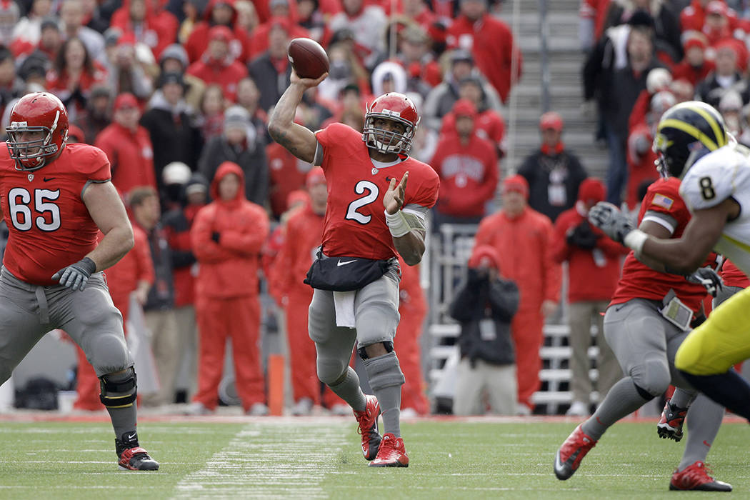 Ohio State quarterback Terrelle Pryor (2) passes with help blocking from offensive linesman Ju ...