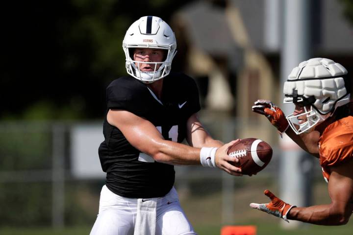 Texas quarterback Sam Ehlinger, left, and running back Jordan Whittington, right, take part in ...