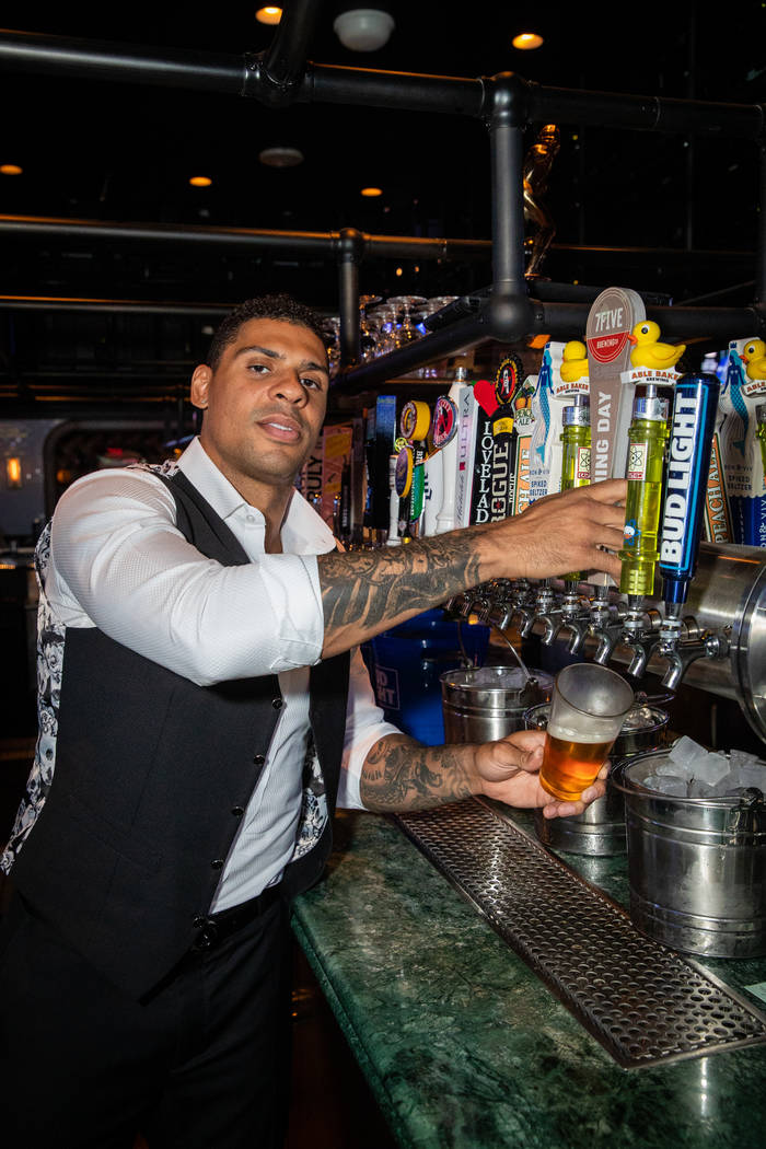 Ryan Reaves is shown tending the bar and posing for the photos at Moneyline Sports Book & Bar a ...