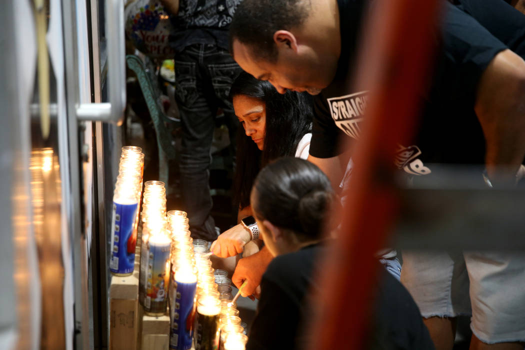 Anthony Randolph, 45, his wife Yesbeth Randolph, 45, and daughter Leyla, 11, light candles duri ...