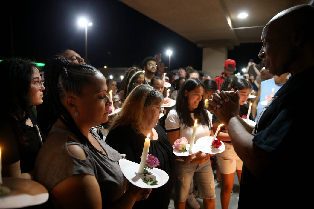 Richard Steele, right, leads a prayer for mourners, including Michelle Corrales-Lewis, left, du ...