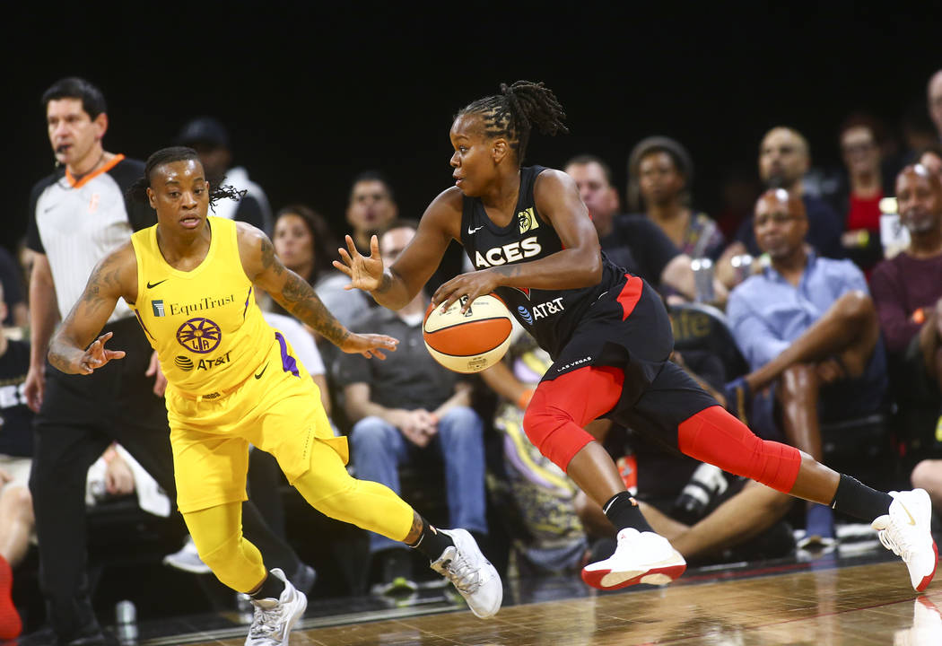 Las Vegas Aces' Epiphanny Prince, right, drives the ball against Los Angeles Sparks' Riquna Wi ...