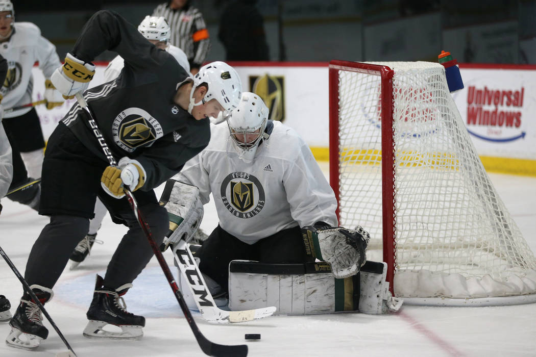 Vegas Golden Knights' Pavel Dorofeyev, left, looks for an open shot against goaltender Jordan K ...