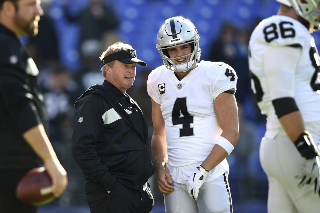 Oakland Raiders coach Jon Gruden, center left, speaks with quarterback Derek Carr before the te ...