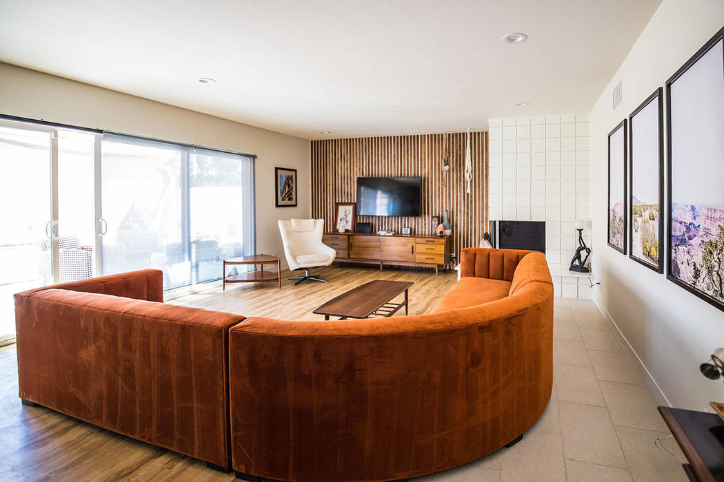 A rust-colored sectional adds another retro dimension among the midcentury furniture pieces. (T ...