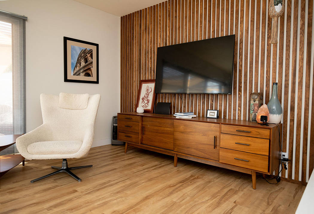 The living room features an accent wall that has strips of wood to match the 1960s vibe. (Tonya ...