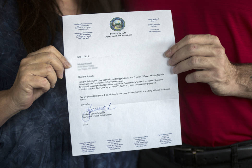 Michael Russell and his mother, Jill Drysdale, hold the letter from the Nevada Department of Co ...