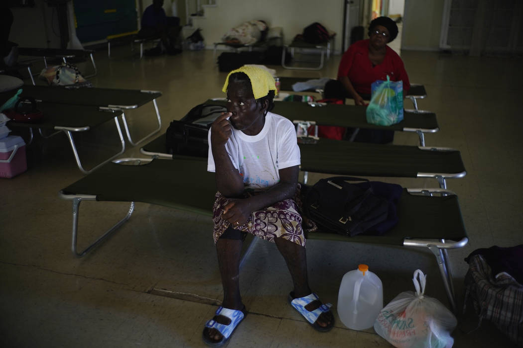 Women sit on cots inside a church now serving as a shelter for residents who will wait out Hurr ...