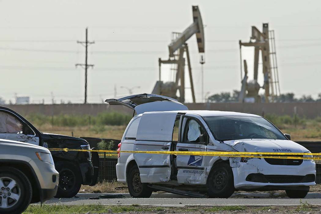 A U.S. Mail vehicle, right, which was involved in Saturday's shooting, is pictured outside the ...