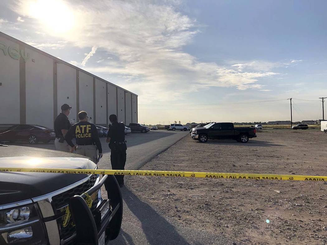 Bureau of Alcohol, Tobacco, Firearms and Explosives agents speak with a local police officer in ...