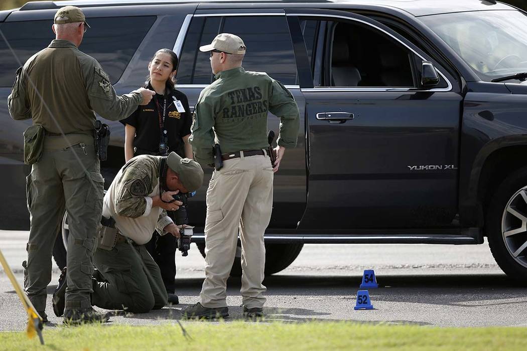 Law enforcement officials process a scene involved in Saturday's shooting, Sunday, Sept. 1, 201 ...