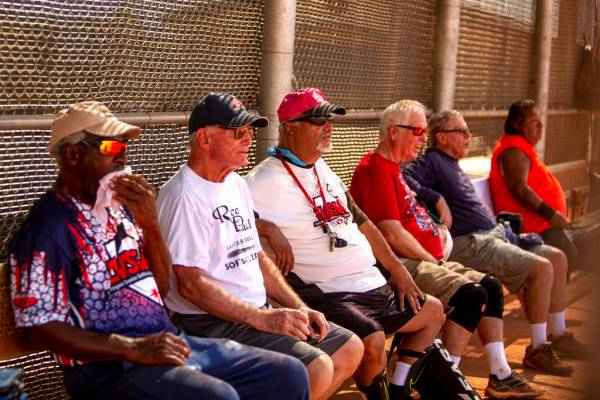 Members of the Las Vegas Senior Softball Association watch the inning of a play during a baseba ...