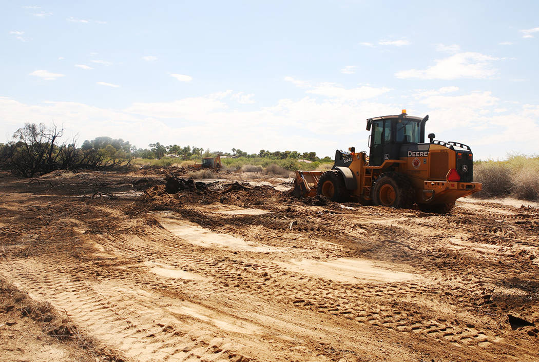 Crews work in the field after a brush fire at Sunset Park on Sunday, Sept. 1, 2019. (Michael Bl ...