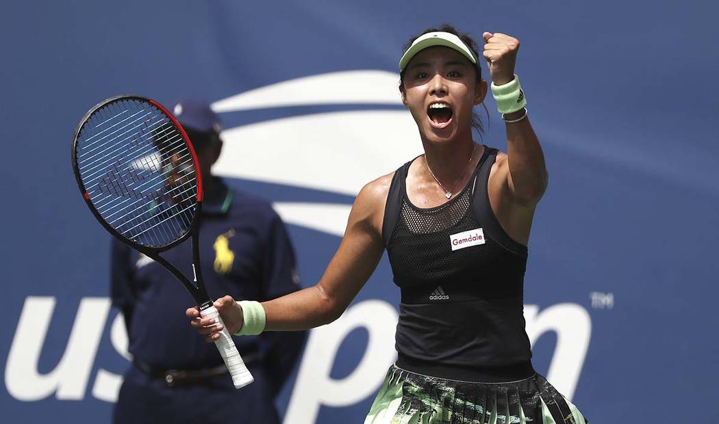 Qiang Wang, of China, reacts after defeating Ashleigh Barty, of Australia, during round four of ...