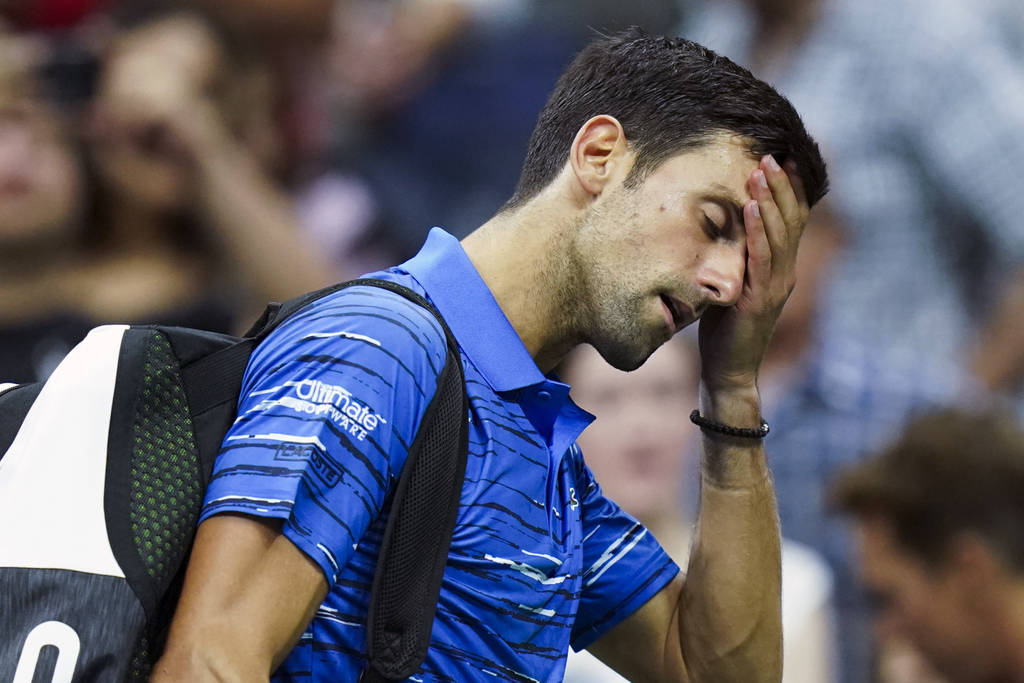 Novak Djokovic, of Serbia, walks off the court as he retires during his match against Stan Wawr ...