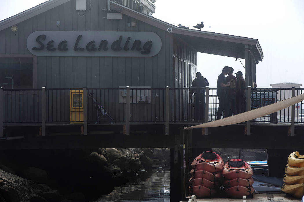 People wait for updates outside of the Truth Aquatics office in Santa Barbara, Calif., on Monda ...