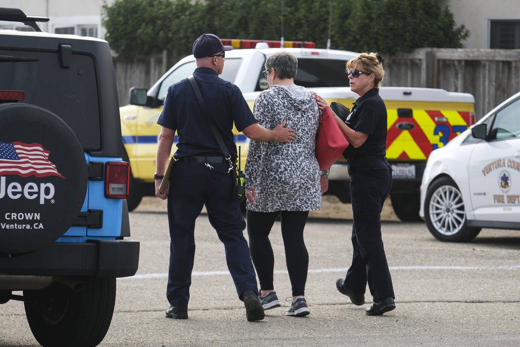 A woman is comforted by a member of the Ventura County Fire department at U.S. Coast Guard Stat ...