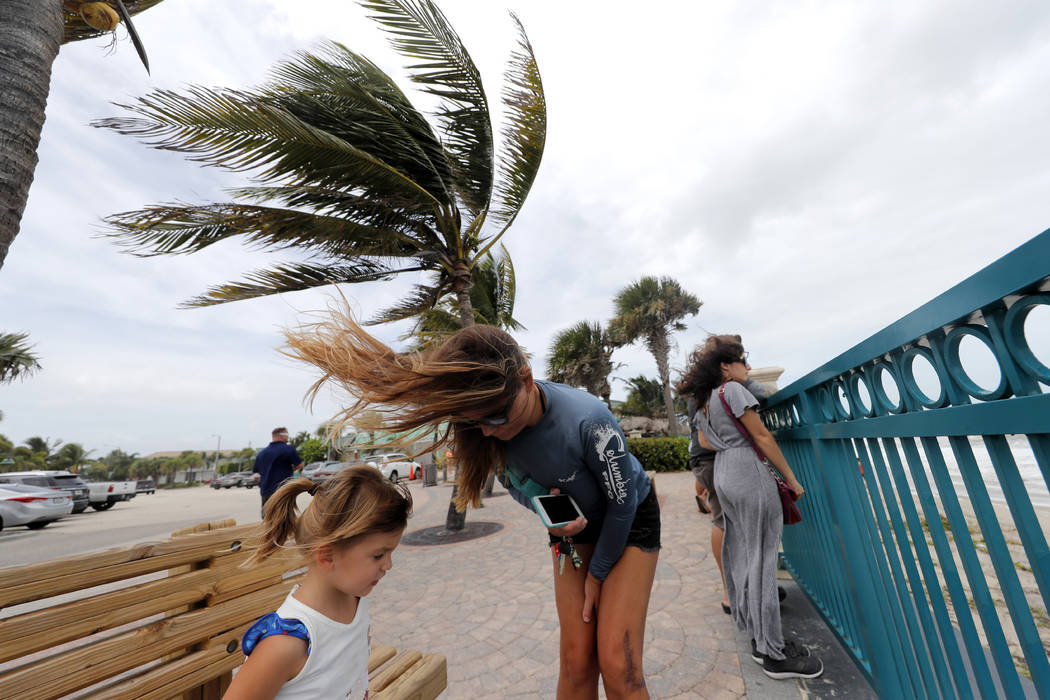 Kristen Davis watches the high surf from a boardwalk overlooking the Atlantic Ocean with her da ...