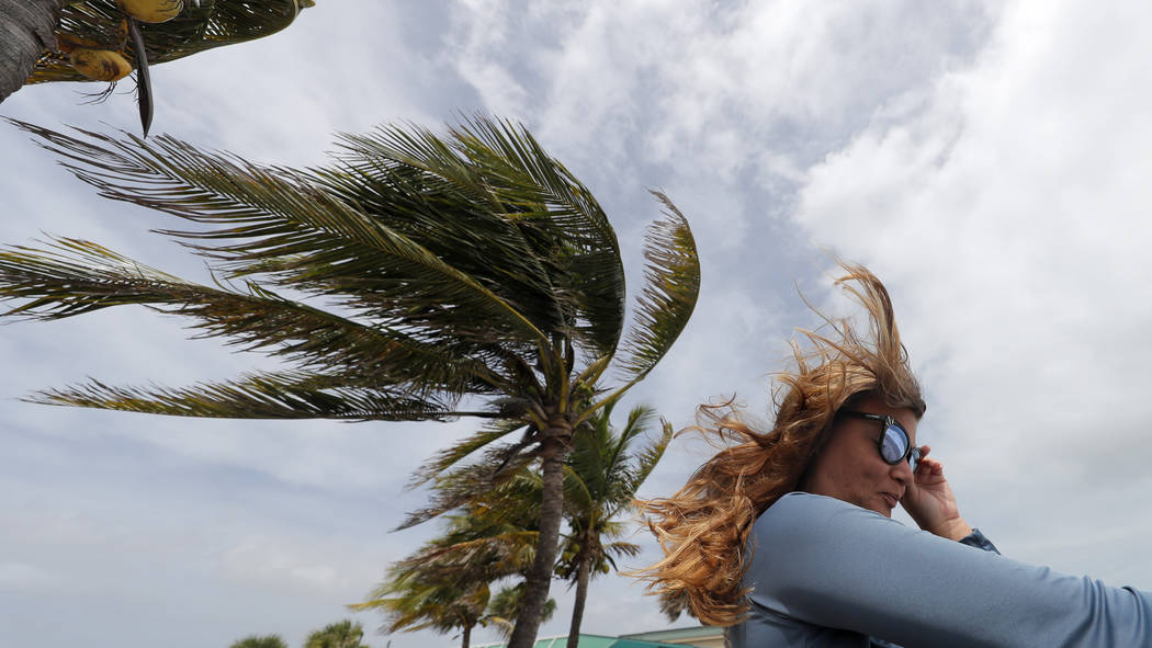 Kristen Davis watches the high surf from a boardwalk overlooking the Atlantic Ocean, as winds f ...