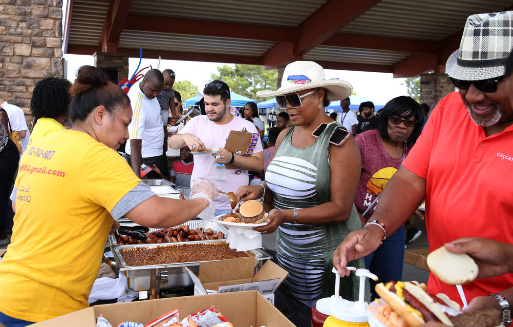 Francis Stevenson, left, owner of Sharp BBQ, serves meals during Rep. Steven Horsford's Labor D ...