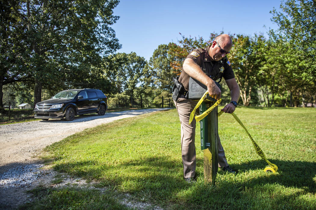 Limestone County Sheriff Sgt. Jonathan Hardiman adds caution tape at the scene of a shooting, T ...