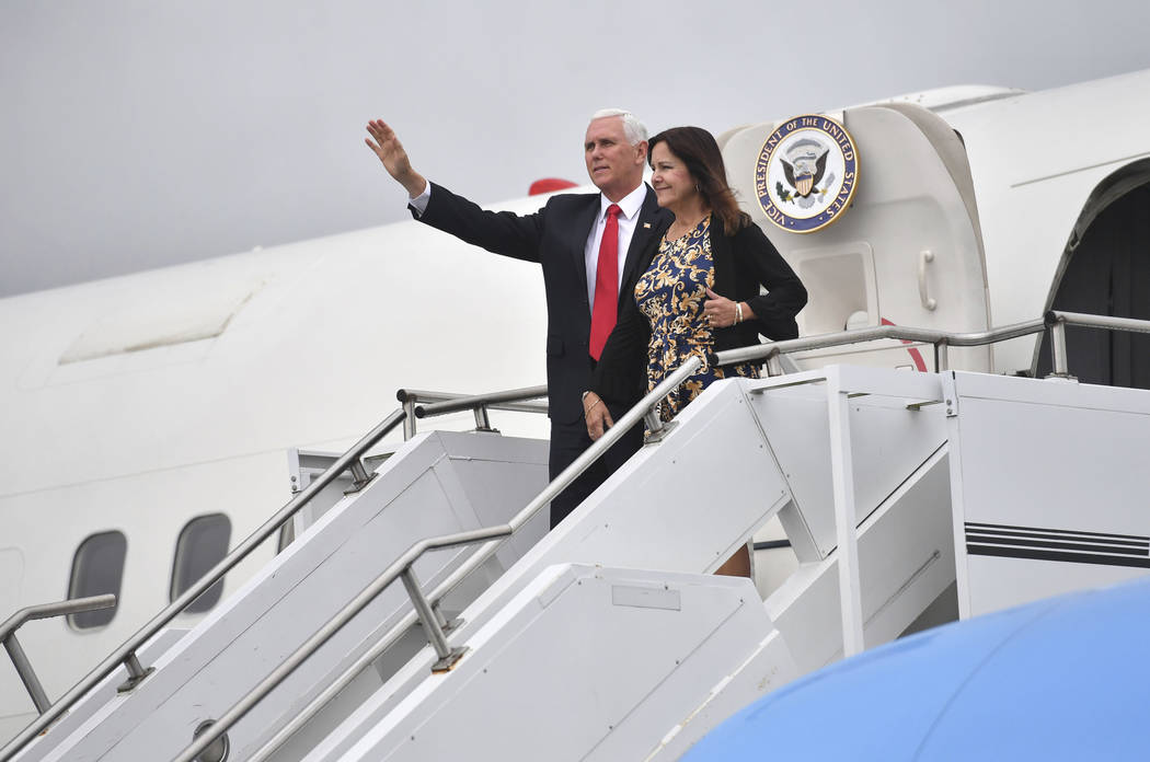 US Vice President Mike Pence and his wife Karen Pence gesture as they arrive at Shannon airport ...