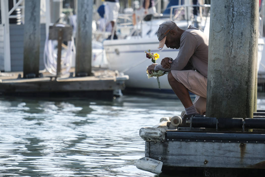 James Miranda, right, of Santa Barbara, holds flowers and takes a moment to reflect at a dock n ...