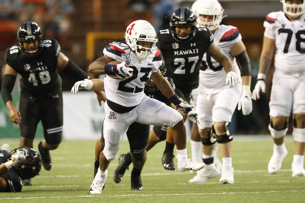 Arizona running back Gary Brightwell (23) runs through the Hawaii defense during an NCAA colleg ...