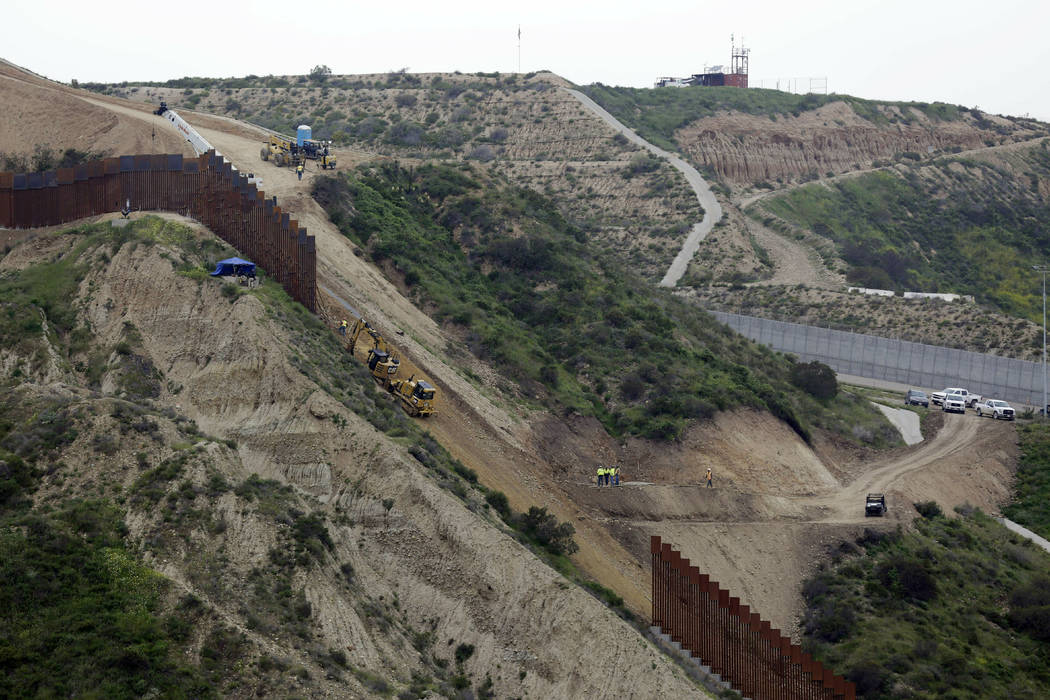 FILE - In this March 11, 2019 photo, construction crews replace a section of the primary wall s ...