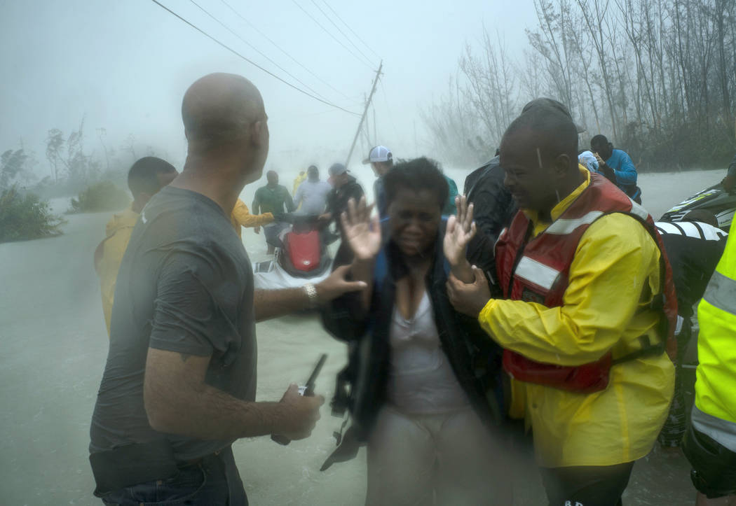 Volunteers rescue several families that arrived on small boats, from the rising waters of Hurri ...