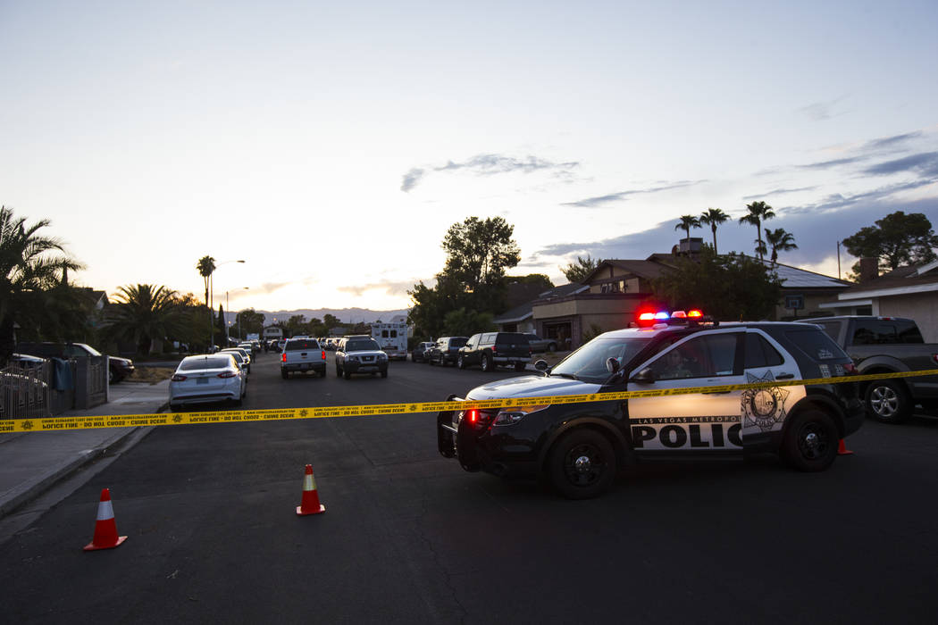 Las Vegas police secure the area around a residential street as they wait for a search warrant ...