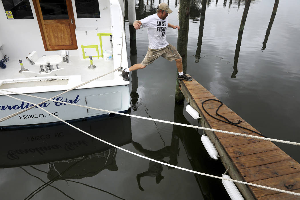 Brian Taylor, captain and owner of the fishing charter boat Carolina Girl, leaps from the boat ...