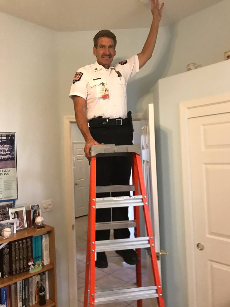 Fire Inspector Dave Marsili checks a smoke alarm after it was installed. (Herb Jaffe)