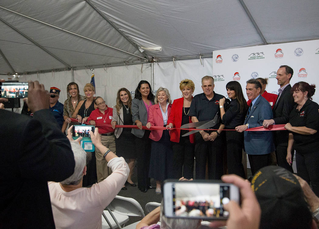 Dr. Arnold Stalk, center, president of Veterans Village, cuts a ribbon during the grand opening ...