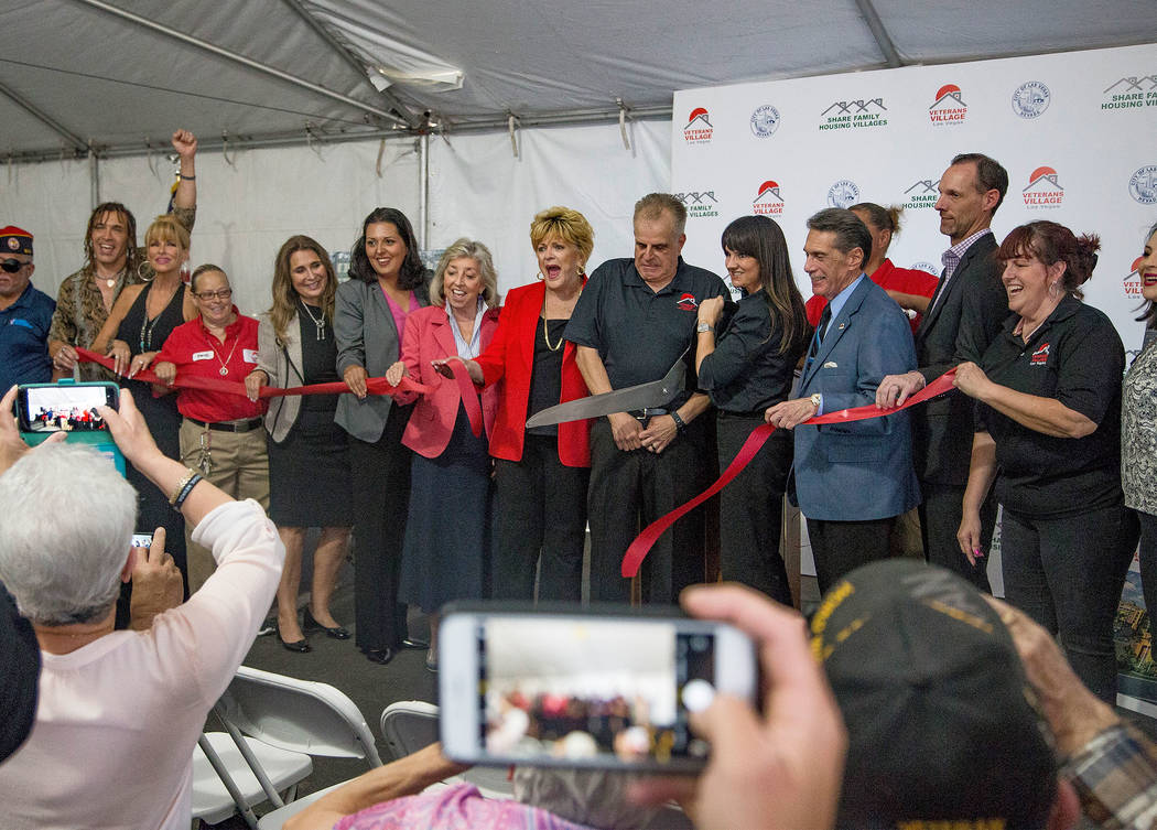 Dr. Arnold Stalk, center, president of Veterans Village, cuts a ribbon during the grand opening ...