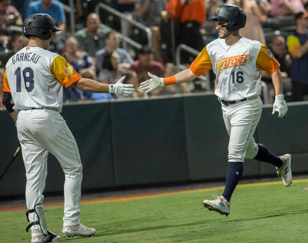 Las Vegas Aviators left fielder Mark Payton (16) gets a high five from Las Vegas Aviators catch ...