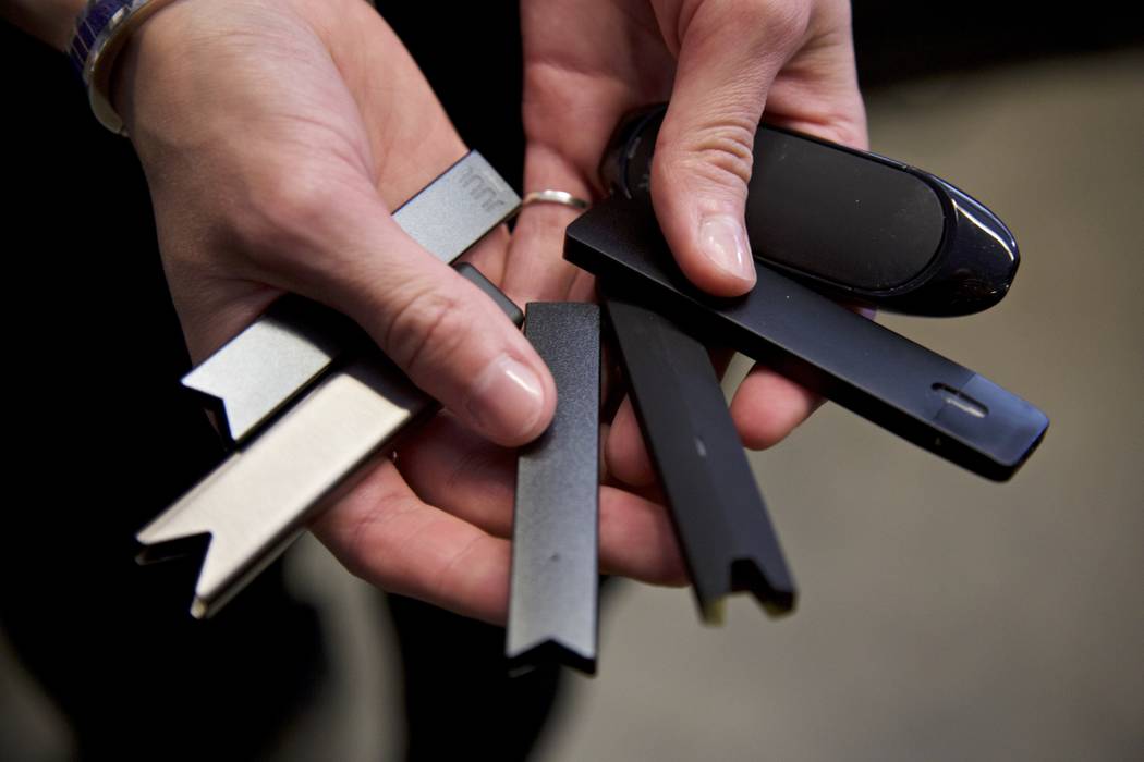 File - In this April 16, 2019, file photo, a researcher holds vape pens in a lab at Portland St ...