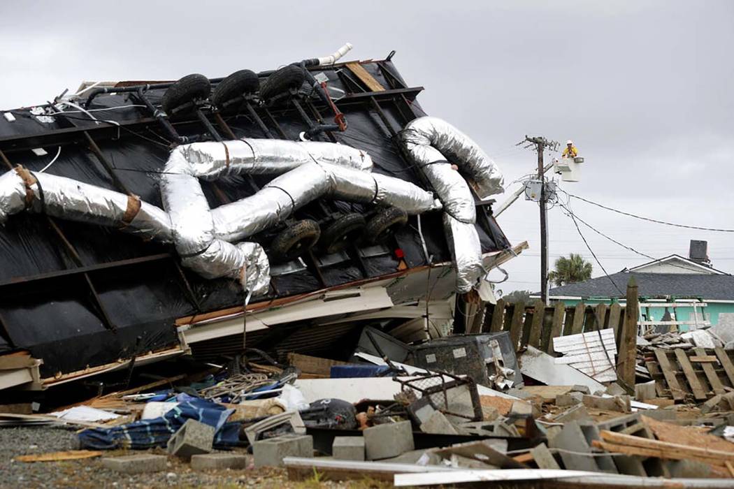 Power company lineman work to restore power after a tornado hit Emerald Isle, N.C. as Hurricane ...