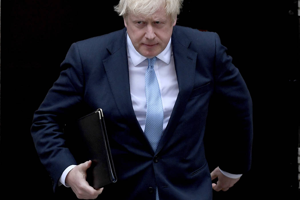 Britain's Prime Minister Boris Johnson walks towards a podium to speak to the media outside 10 ...