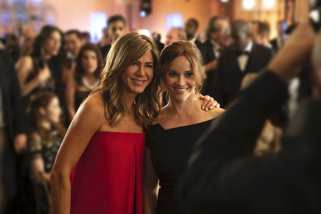 This image released by Apple TV Plus, Jennifer Aniston, left, and Reese Witherspoon appear in a ...