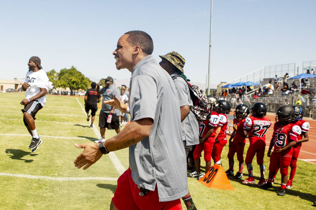 Devin Conway celebrates with coaches during a play made by TMT Red Lions players at Bonanza Hig ...