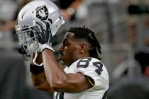 In this Aug. 15, 2019, file photo, Oakland Raiders wide receiver Antonio Brown (84) puts on his ...