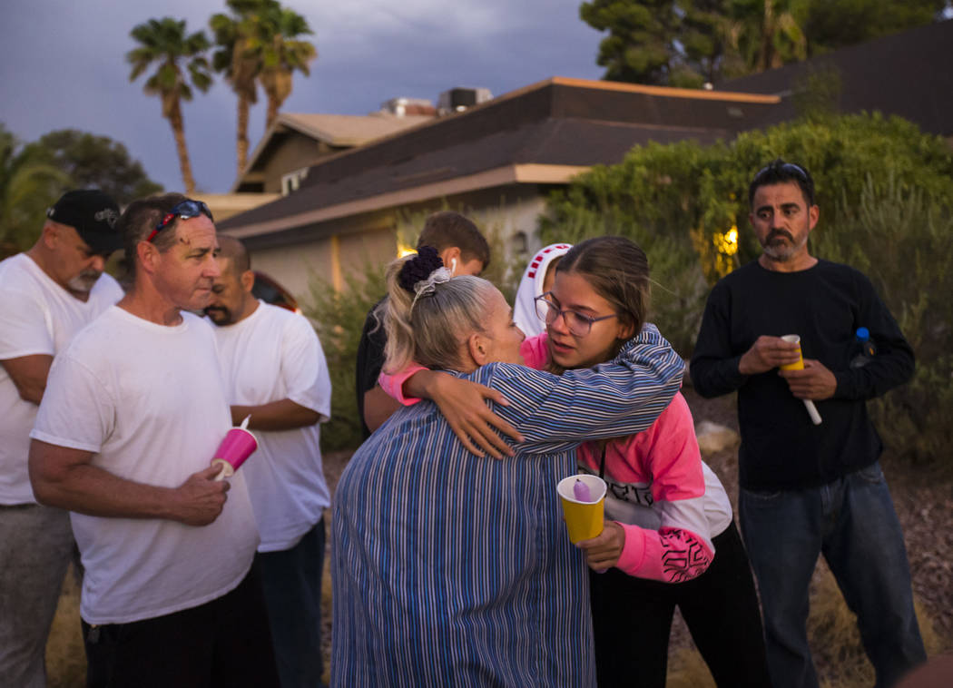 Kelsi Jackson, 15, center right, hugs her grandmother, Mary Ann Ratay, during a vigil in memory ...