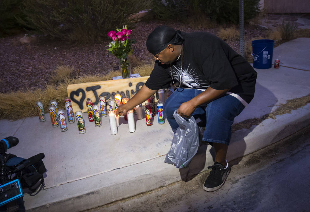 Mario Smith lights candles in memory of Jennifer Ratay during a vigil outside of the home where ...