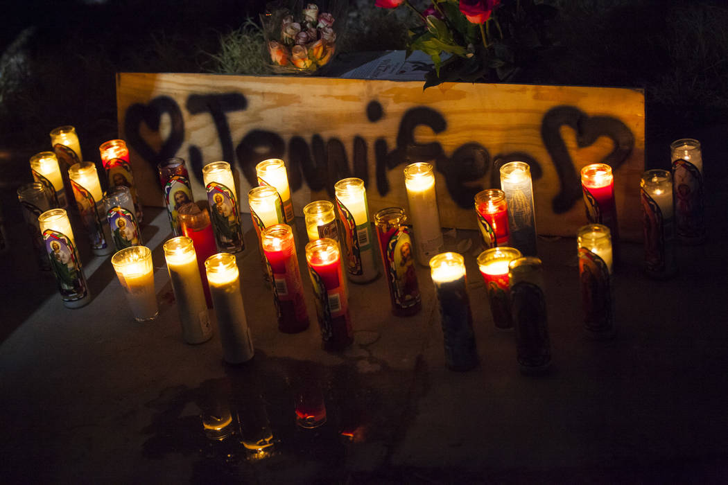 Candles light a sign during a vigil in memory of Jennifer Ratay outside of the home where she w ...
