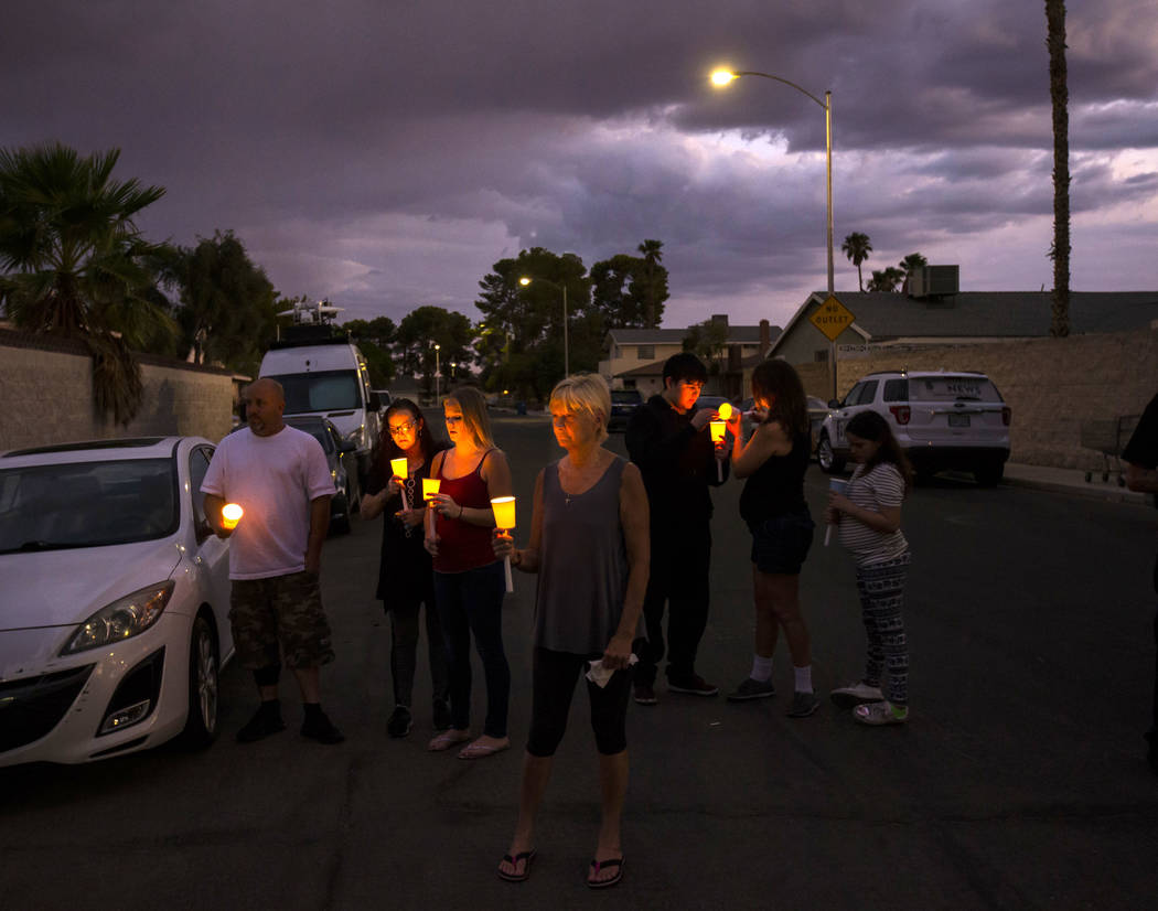 People hold candles during a vigil in memory of Jennifer Ratay outside of the home where she wa ...
