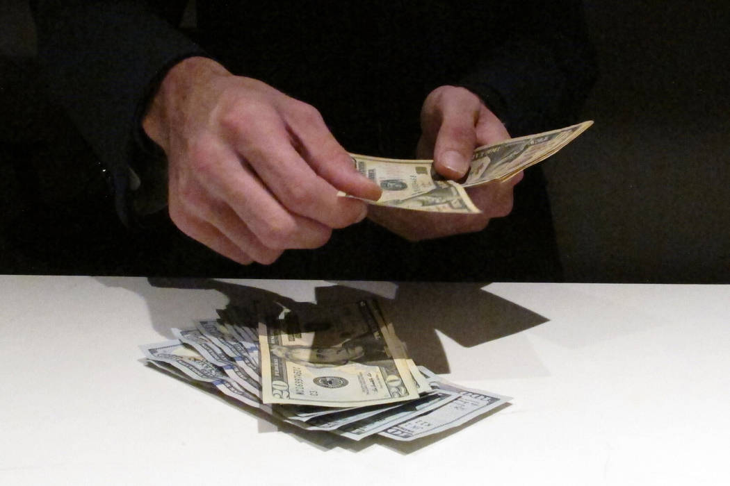 In this June 27, 2019 photo, a clerk counts money at the new sportbook at Bally's casino in Atl ...